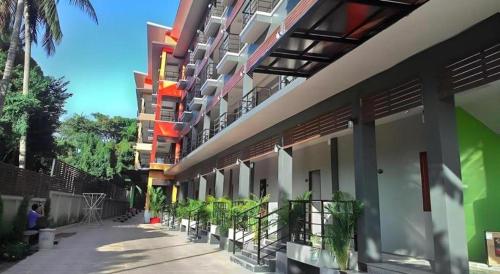 a row of buildings with plants on a sidewalk at Waenpetch place Hotel in Ubon Ratchathani