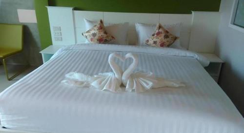 a white bed with two white bows on it at Waenpetch place Hotel in Ubon Ratchathani