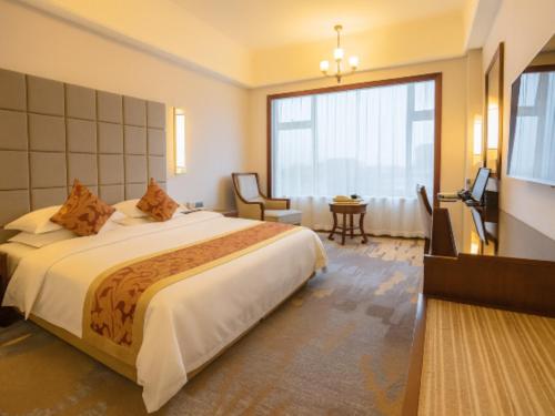 a hotel room with a bed and a large window at Putian Haiyuan International Hotel in Putian