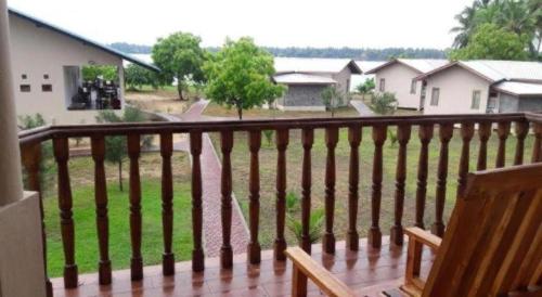 a wooden balcony with a view of a yard at Naaval Hotel in Batticaloa