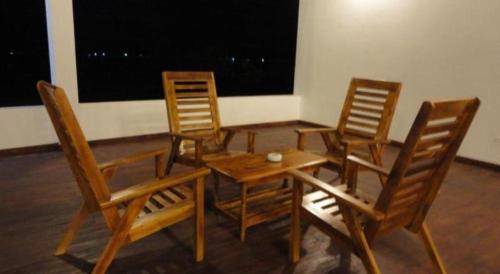 three chairs and a table and a table and a table and chairs at Naaval Hotel in Batticaloa