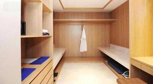a small bathroom with wooden cabinets and a towel at The Rinra in Makassar