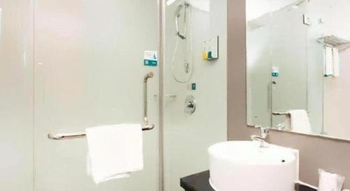 a bathroom with a toilet and a sink and a mirror at City Comfort Inn Xiangyang Railway Station in Xiangyang