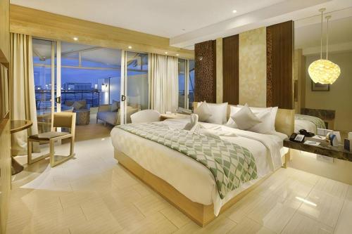 a bedroom with a large bed and a living room at The Rinra in Makassar