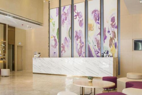 a lobby with a table and purple chairs at Lavande Hotel·Dongxing Port in Fangcheng