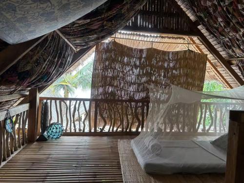 a bedroom with a bed in a straw hut at Balay Asiano in Puerto Princesa City