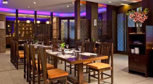 a dining room with a long table and chairs at Chinflux Mandarin Hotel in Dongguan