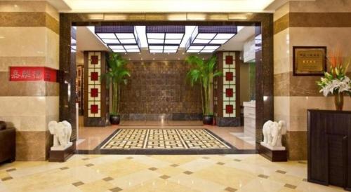 a lobby of a building with a hallway with plants at Chinflux Mandarin Hotel in Dongguan