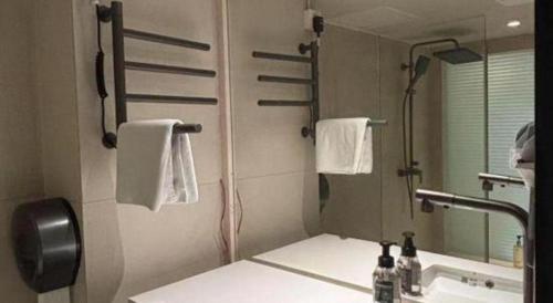 a bathroom with a sink and a mirror at Oriental Hotel in Dongguan
