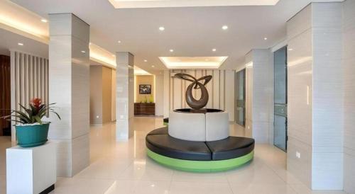 a lobby with a statue in the middle of it at Lotus Hotel Subang in Bandung