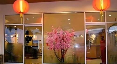 a window of a store with a vase of pink flowers at Hotel Formosa in Manado