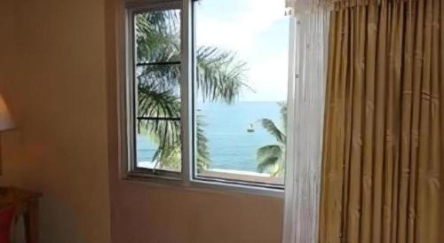 a window in a room with a view of the ocean at Hotel Formosa in Manado