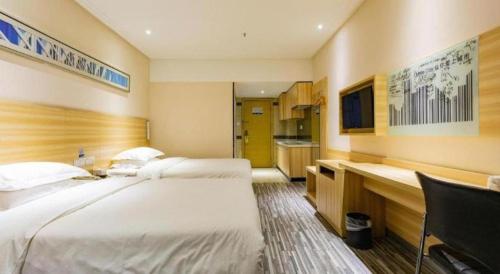 a hotel room with two beds and a desk at City Comfort Inn Wuhan Hankou Railway Station West Square in Wuhan