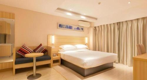 a hotel room with a bed and a table at City Comfort Inn Wuhan Hankou Railway Station West Square in Wuhan