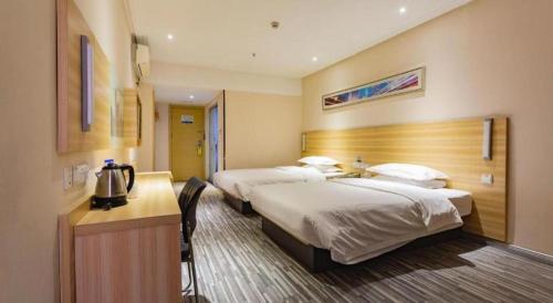 a hotel room with two beds and a desk at City Comfort Inn Wuhan Hankou Railway Station West Square in Wuhan