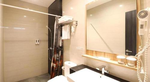 a bathroom with a sink and a mirror at Fitra Hotel Majalengka in Majalengka