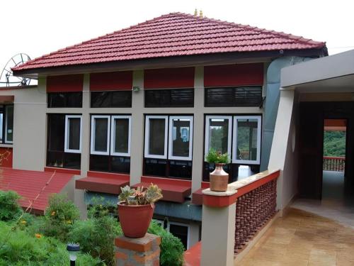 a house with a red roof and some plants at New Dakshinkali Village Resort in Kathmandu