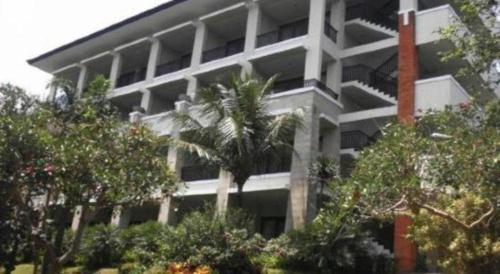 a large white building with palm trees in front of it at The Oxalis Regency Hotel in Magelang