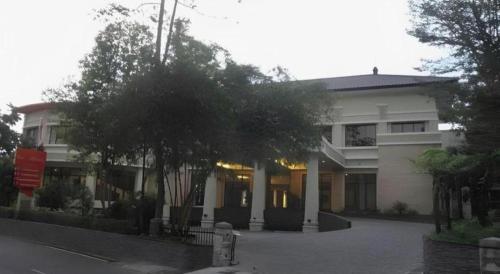 a white building with a tree in front of it at The Oxalis Regency Hotel in Magelang