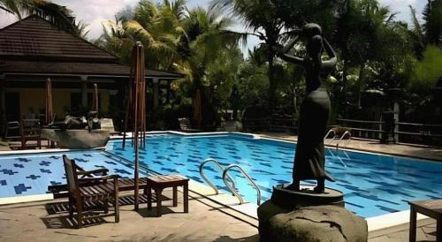 a statue of a woman standing next to a swimming pool at The Oxalis Regency Hotel in Magelang