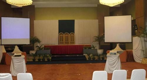 a room with two large screens and white chairs at The Oxalis Regency Hotel in Magelang
