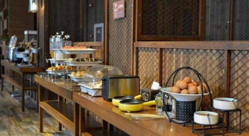 a buffet line with plates of food and eggs at James Joyce Coffetel Tianjin Railway Station Jinshiqiao Metro Station Branch in Tianjin