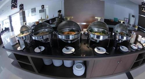 a buffet with four bowls of food on a table at Amantis Hotel in Demak