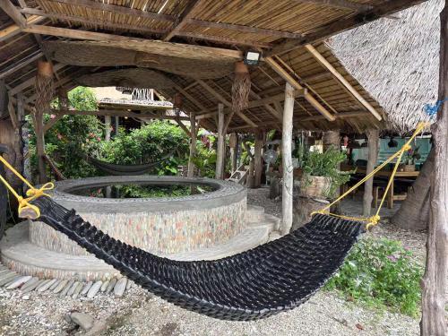 a hammock hanging from a building in a garden at Balay Asiano in Puerto Princesa City
