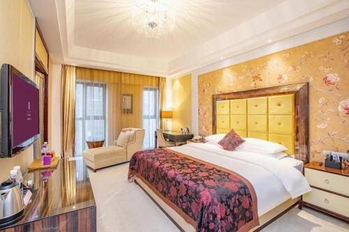 a bedroom with a large bed and a living room at Fortune International Hotel in Xiawutun