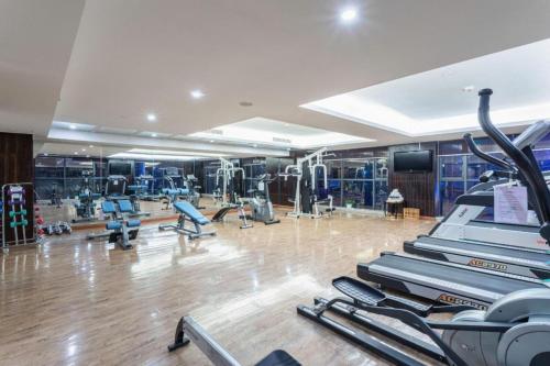 a gym with treadmills and machines in a room at Fortune International Hotel in Xiawutun