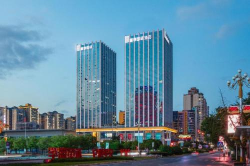 two tall skyscrapers in a city at dusk at Fortune International Hotel in Xiawutun