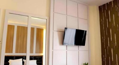 a flat screen tv on the wall of a hotel room at Hotel Grand Permata Hati in Banda Aceh