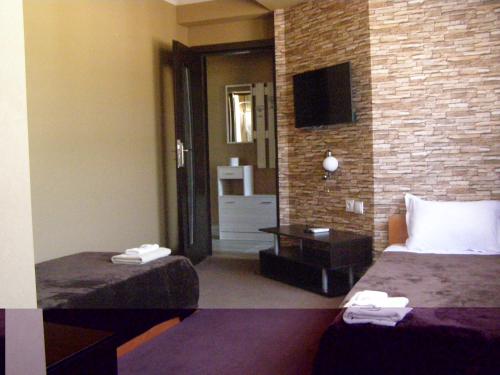 a hotel room with two beds and a television at Guesthouse Avenue in Kirkovo