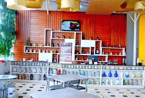 a restaurant with a counter with tables and vases at Grant Hotel Subang in Bandung