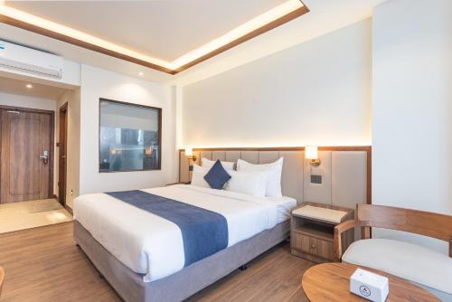 a hotel room with a large bed and a table at Hotel Sara Sadan in Kathmandu