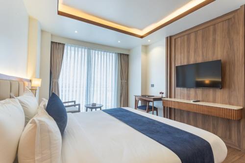 a hotel room with a bed and a flat screen tv at Hotel Sara Sadan in Kathmandu