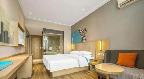 a bedroom with a white bed and a couch at City Comfort Inn Dangtu High Speed East Railway Station RT-Mart in Ma'anshan
