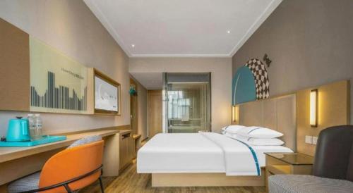 a bedroom with a large white bed and a couch at City Comfort Inn Dangtu High Speed East Railway Station RT-Mart in Ma'anshan