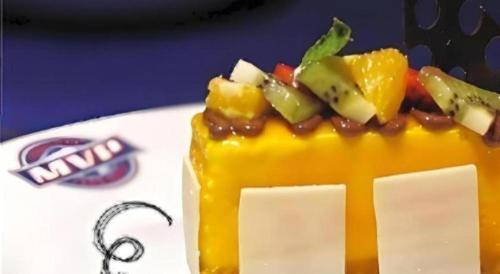 a piece of cake with fruit on top on a plate at Tematik Hotel Pluit in Jakarta