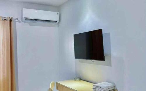 a bathroom with a tv on the wall at Tematik Hotel Pluit in Jakarta