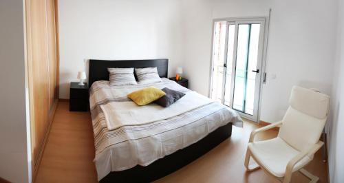 Salir de PortoにあるSalir Do Portoのベッドルーム(大型ベッド1台、白い椅子付)