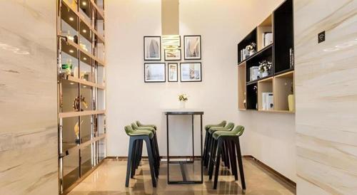 a room with a table and two green stools at City Comfort Inn Nanning Railway Station Guangxi University in Nanning