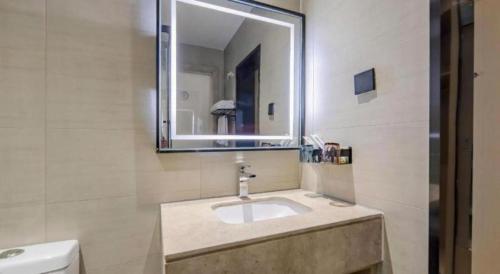 a bathroom with a sink and a mirror at City Comfort Inn Nanning Railway Station Guangxi University in Nanning