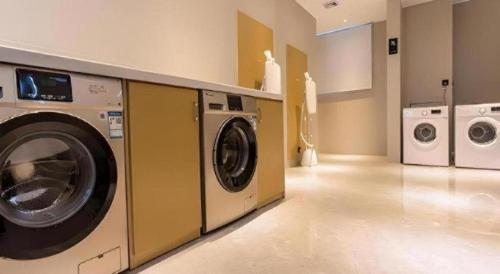 a laundry room with a washing machine and a washer and dryer at City Comfort Inn Nanning Railway Station Guangxi University in Nanning