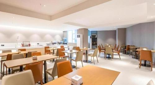 a restaurant with tables and chairs and a kitchen at City Comfort Inn Nanning Railway Station Guangxi University in Nanning