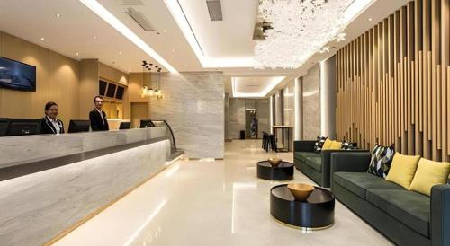 a lobby of a hotel with two men sitting at a counter at City Comfort Inn Nanning Railway Station Guangxi University in Nanning