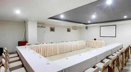 a lecture hall with rows of chairs and a screen at Plaza Hotel Tegal in Tegal