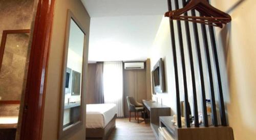 a hotel room with a bed and a staircase to a room at Plaza Hotel Tegal in Tegal