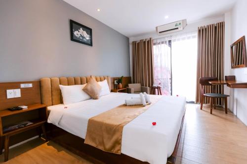 a bedroom with a large white bed and a window at Gardenia Hue Hotel in Hue