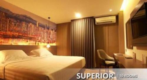 a hotel room with a bed and a chair at Plaza Hotel Tegal in Tegal